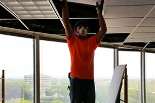 man cleaning ceiling tiles